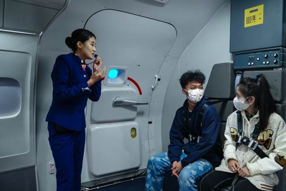 图为体验员试坐乘务员座位